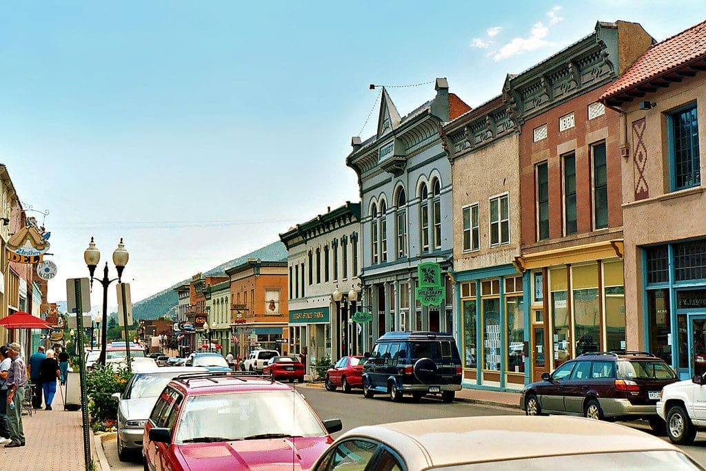 Picture of Miner street in Idaho Springs, lots of colorful cars and buildings with mountains in background